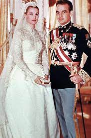 Grace Kelly on wedding day with Prince Rainer wearing lace long sleeve wedding dress with matching veil 